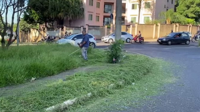 Morador usa a própria máquina para cortar mato alto na avenida do Café em Ribeirão