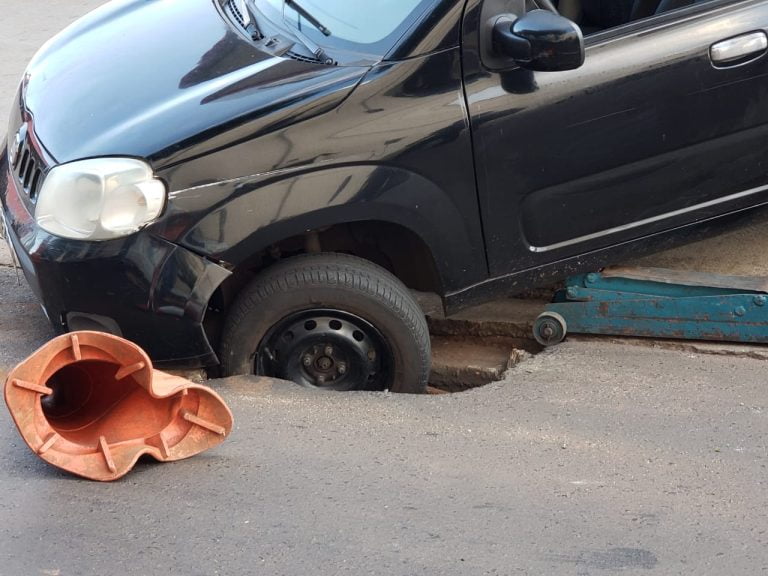 Asfalto cede e carro cai em buraco na rua Mariana Junqueira
