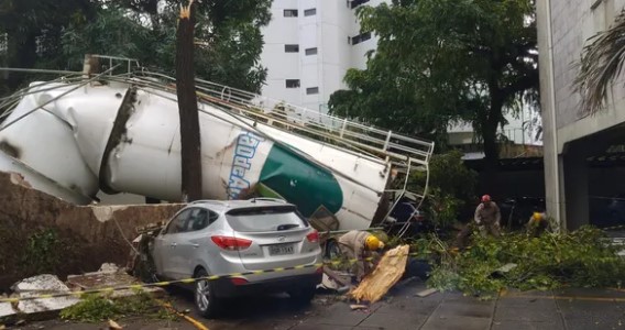 Caixa d’água de supermercado cai e destrói muro e carros
