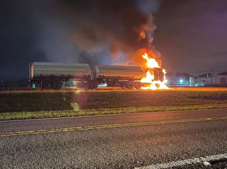 Caminhão pega fogo ao passar por cima de motocicleta caída em rodovia