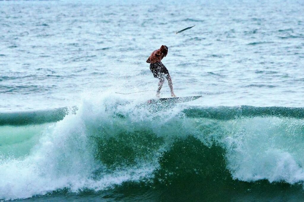 fotógrafo registra momento raro de surfista pegando peixe com a mão durante onda em ubatuba