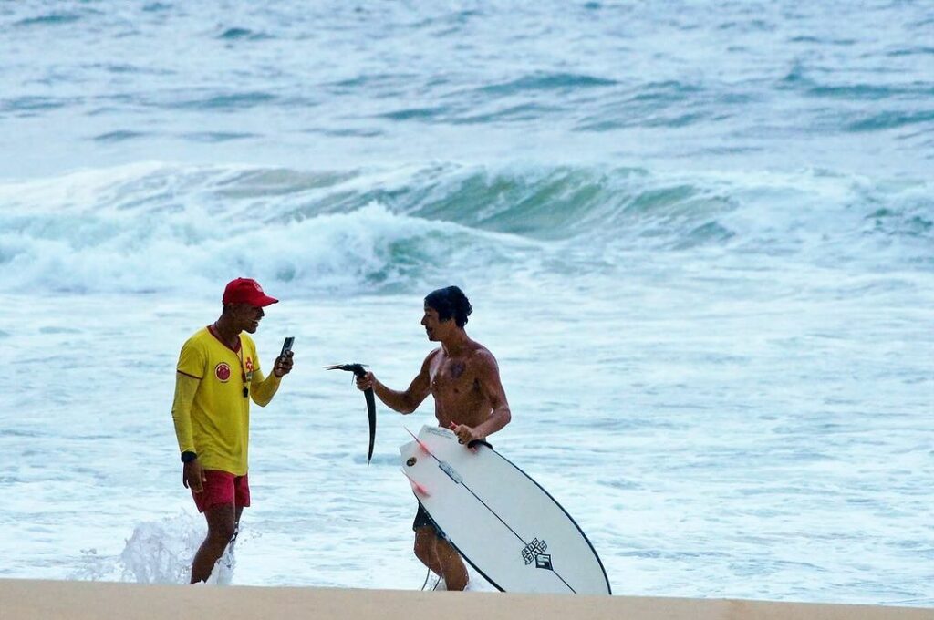fotógrafo registra momento raro de surfista pegando peixe com a mão durante onda em ubatuba