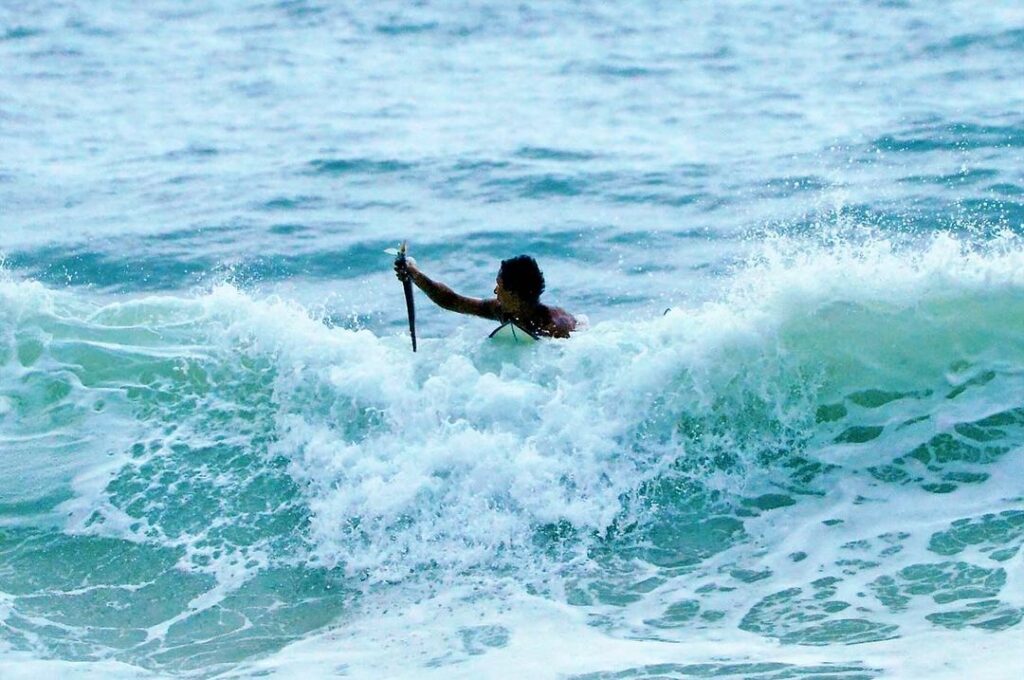 fotógrafo registra momento raro de surfista pegando peixe com a mão durante onda em ubatuba