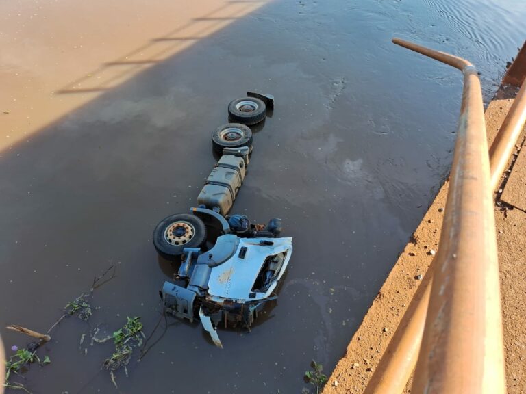Horas após acidente, corpo de caminhoneiro segue preso em cabine de veículo submerso