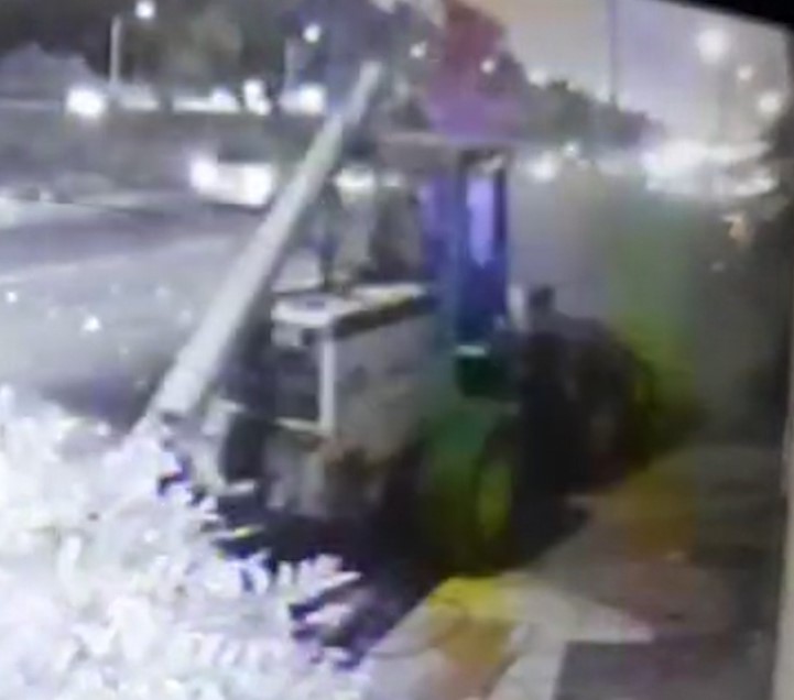 Pá carregadeira cai de carreta e atinge poste e carro estacionado