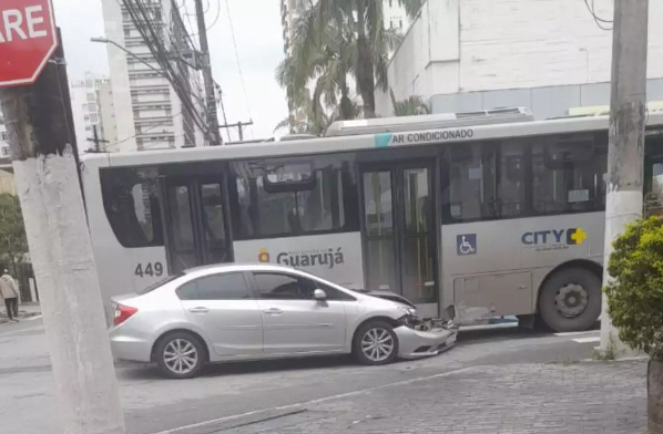 Carro de passeio ignora “pare”, colide em ônibus e acaba preso embaixo de veículo em Guarujá