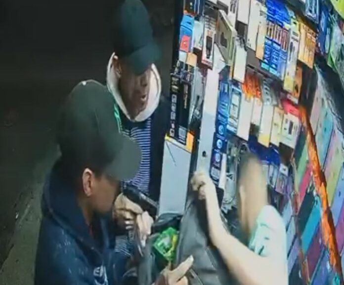 Um dos criminosos aparece com uma arma e obriga o dono do estabelecimento a ensinar ele a ligar a moto, para que assim, ele consiga fugir.