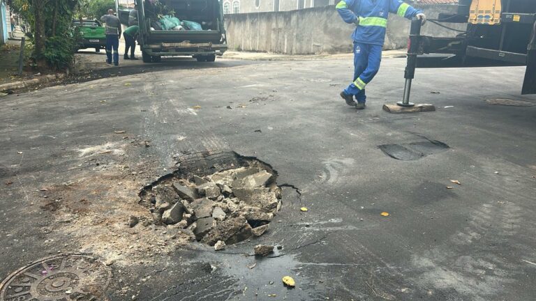 Asfalto cede e caminhão da coleta de lixo fica preso em São José
