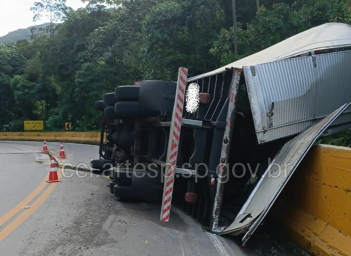 Caminhão tomba e interdita pista de rodovia do litoral