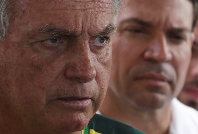 O ex-presidente Jair Bolsonaro fala com a imprensa observado por Alexandre Ramagem | REUTERS/Ricardo Moraes O ex-presidente Jair Bolsonaro fala com a imprensa observado por Alexandre Ramagem | REUTERS/Ricardo Moraes