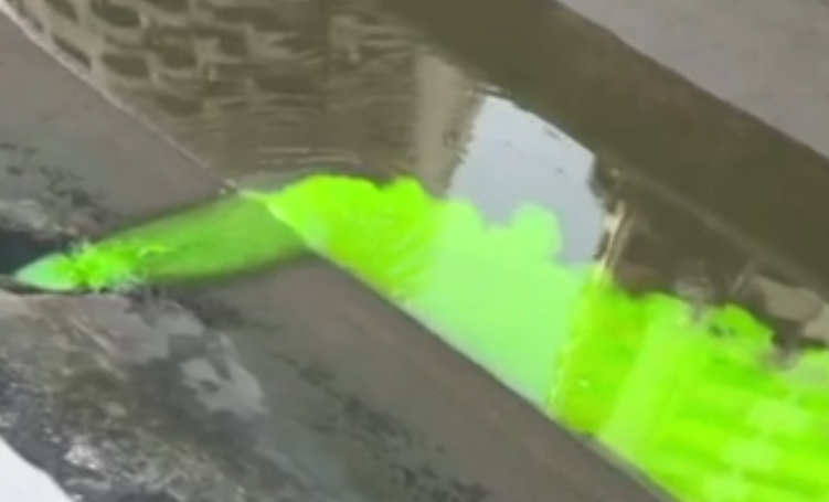 Líquido verde aparece em canal de Santos e condomínio leva multa por descarte irregular