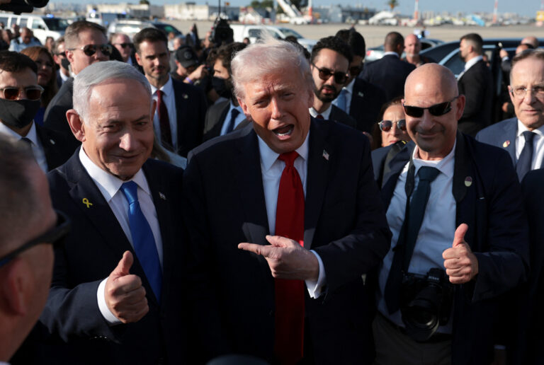 O presidente dos EUA, Donald Trump, gesticula ao lado do primeiro-ministro israelense, Benjamin Netanyahu, no Aeroporto Internacional Ben Gurion, enquanto Trump deixa Israel a caminho de Sharm El-Sheikh, Egito, para participar de uma cúpula de líderes mundiais sobre o fim da guerra de Gaza, em meio a uma troca de prisioneiros e reféns mediada pelos EUA e um acordo de cessar-fogo entre Israel e o Hamas, em Lod, Israel, em 13 de outubro de 2025 | REUTERS/Evelyn Hockstein