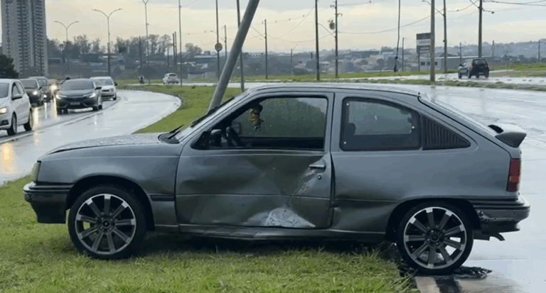 Chuva intensa causa acidente e deixa carro destruído e poste pendurado na John Boyd Dunlop