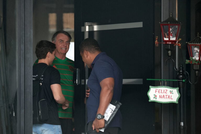 O ex-presidente do Brasil, Jair Bolsonaro, aparece na porta de sua casa, durante sua prisão domiciliar, em Brasília | REUTERS/Mateus Bonomi