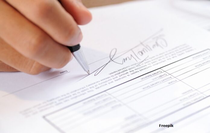 Closeup of person signing document with ball pen A decisão estabelece multa diária de R$ 5 mil em caso de descumprimento. O valor pode chegar a R$ 100 mil.