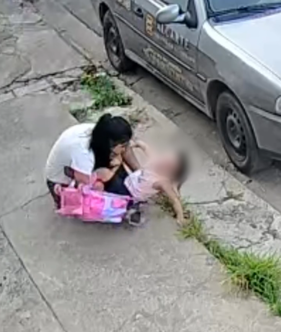 Mulher tropeça em buraco na calçada com a filha pequena nos braços Mulher tropeça em buraco na calçada com a filha pequena nos braços