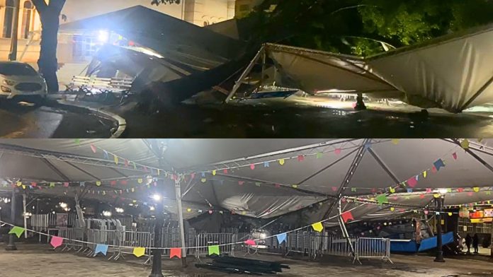 Árvore cai sobre estrutura de festa junina após chuva forte Árvore cai sobre estrutura de festa junina após chuva forte