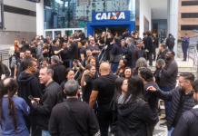 Bancários da Caixa fazem protesto no bairro Gonzaga, em Santos; greve completa seu 6º dia